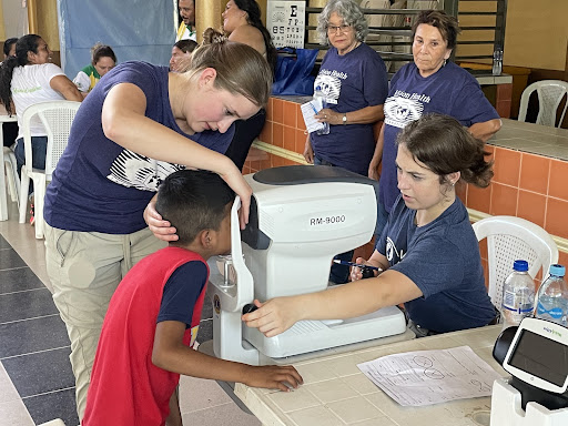 Fellow volunteer member and I examining a childs eyes with Retinomax Machine